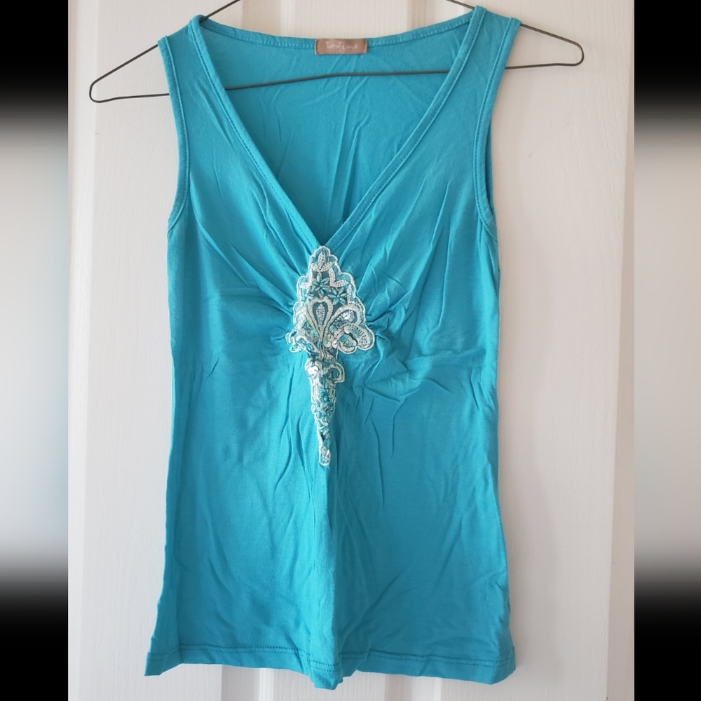 A teal colored tank top with adorned with sequins, beads and embroidery